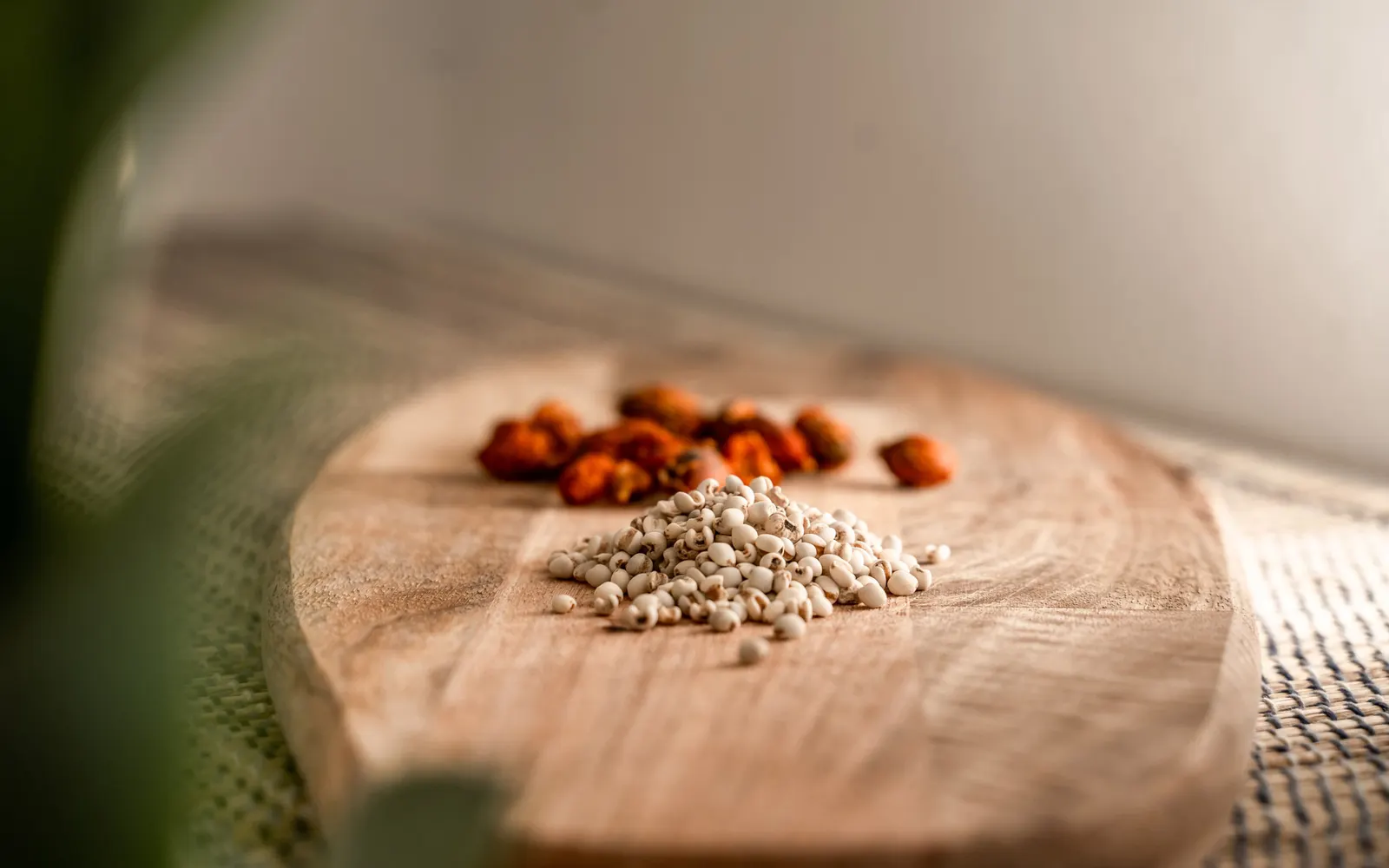 Produktfotografie im Detail: Kräuter und Samen auf einem Holzbrett